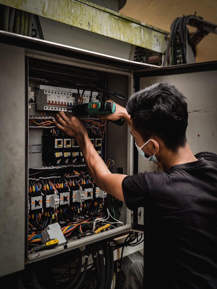 A Man Working on the Circuit Breaker Switch